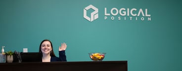 Receptionist at desk waving